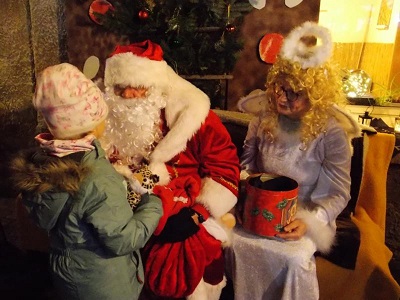 Weihnachtsmann lauscht den Liedern und Gedichten der Kinder